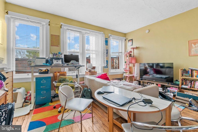 home office with a textured ceiling and hardwood / wood-style floors