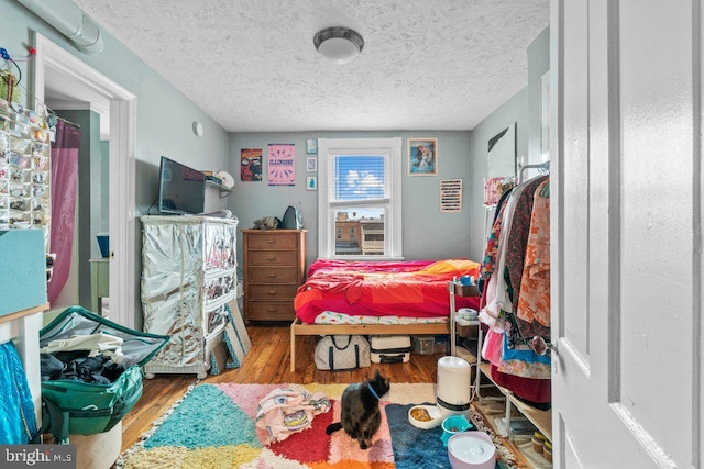 bedroom with wood finished floors and a textured ceiling