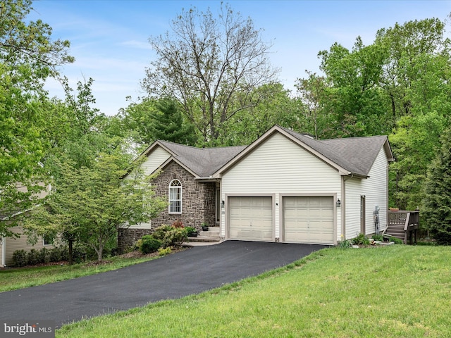 view of front of house with a garage, driveway, stone siding, a front lawn, and roof with shingles