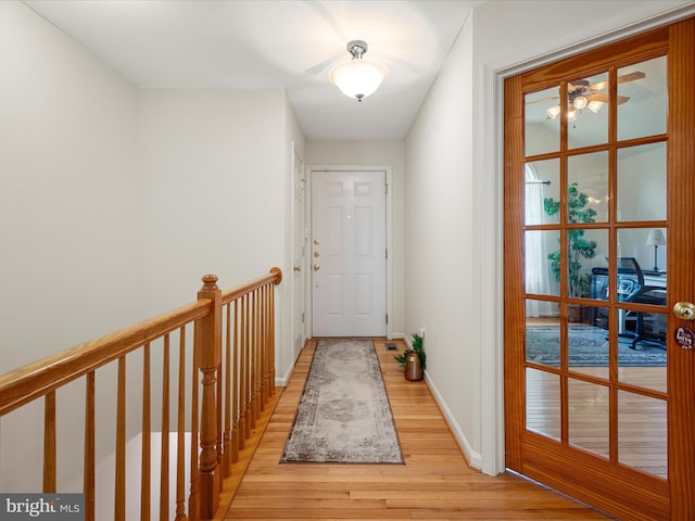 doorway to outside with light wood-style floors, baseboards, and a ceiling fan