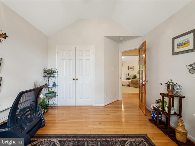 office area featuring light wood-type flooring, lofted ceiling, french doors, and baseboards