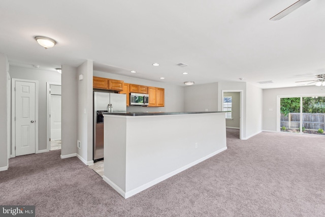 kitchen with light colored carpet, stainless steel appliances, baseboards, and ceiling fan