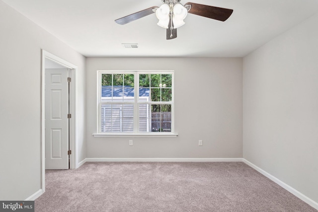 spare room with baseboards, ceiling fan, carpet flooring, and visible vents