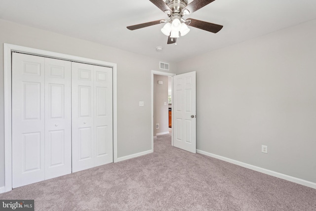 unfurnished bedroom with carpet flooring, a ceiling fan, a closet, visible vents, and baseboards