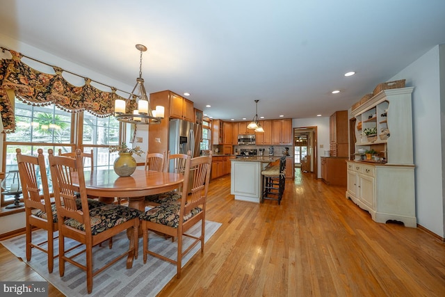 dining area featuring light wood-style floors, recessed lighting, and a chandelier