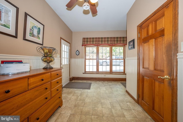 entryway featuring ceiling fan and wainscoting