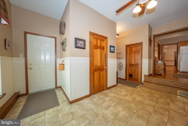 entryway featuring a wainscoted wall, a ceiling fan, and visible vents