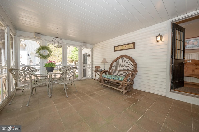 sunroom with wood ceiling and tile patterned flooring