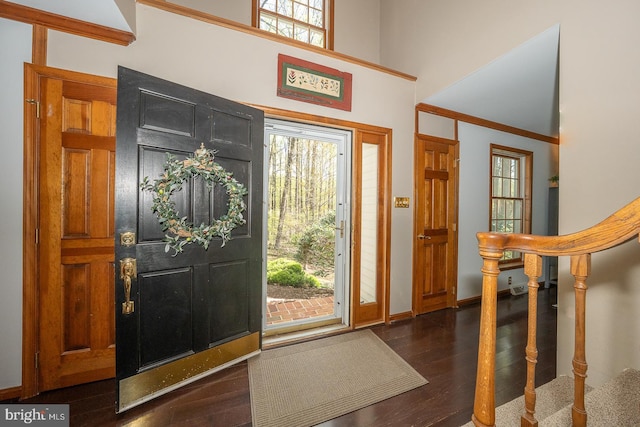 foyer featuring stairs, baseboards, dark wood finished floors, and a high ceiling
