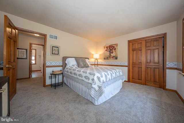 bedroom with baseboards, light carpet, and visible vents