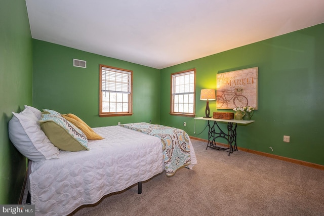 carpeted bedroom with visible vents and baseboards