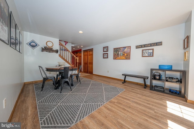 dining room featuring baseboards, recessed lighting, wood finished floors, and stairway