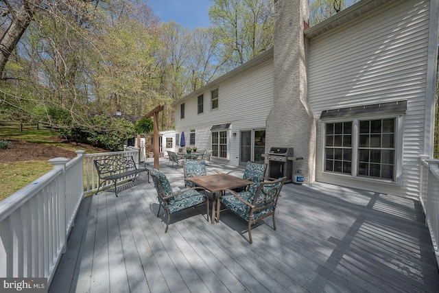 deck with outdoor dining space and grilling area