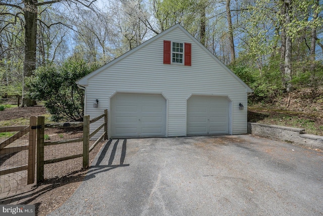 detached garage featuring fence