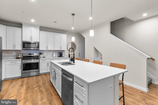 9451 James Macgowan Ln, Owings Mills, MD 21117 - kitchen with tasteful backsplash, appliances with stainless steel finishes, white cabinets, a sink, and a kitchen breakfast bar