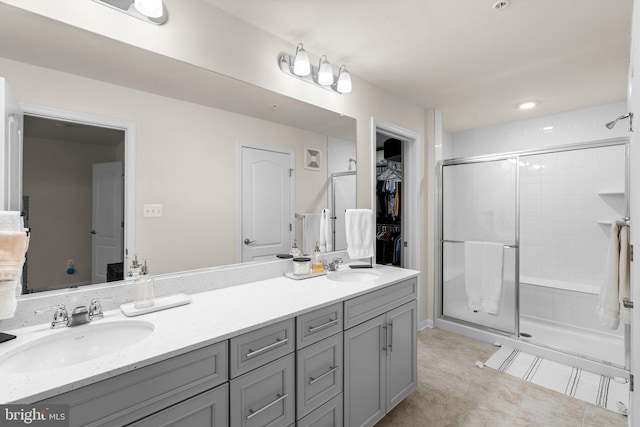 9451 James Macgowan Ln, Owings Mills, MD 21117 - bathroom featuring a walk in closet, a stall shower, double vanity, and a sink