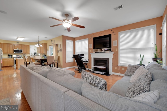 2362 Sequoia Grove St, Waldorf, MD 20601 - living area featuring visible vents, a fireplace with flush hearth, baseboards, a ceiling fan, and light wood-style flooring