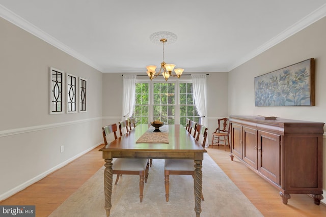 dining area with crown molding, baseboards, a chandelier, and light wood-style floors