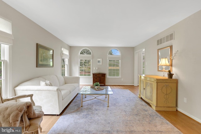 living area with visible vents, light wood finished floors, and baseboards