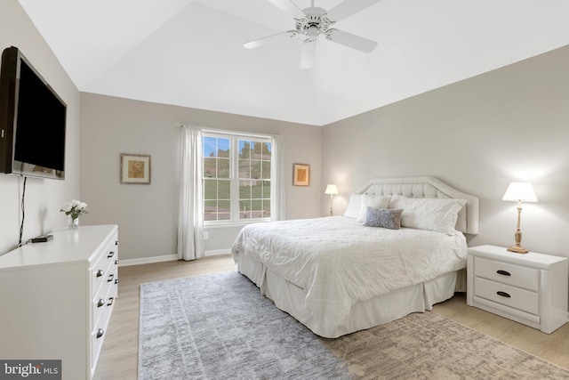 bedroom featuring baseboards, ceiling fan, lofted ceiling, and light wood finished floors