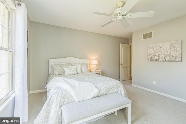 bedroom with light colored carpet, visible vents, a ceiling fan, and baseboards
