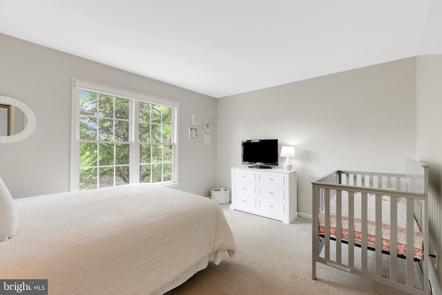 bedroom featuring light colored carpet and baseboards