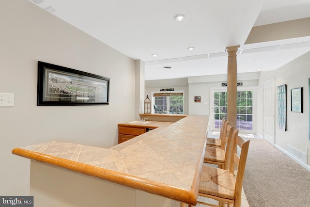 bar featuring carpet flooring, a sink, visible vents, recessed lighting, and ornate columns