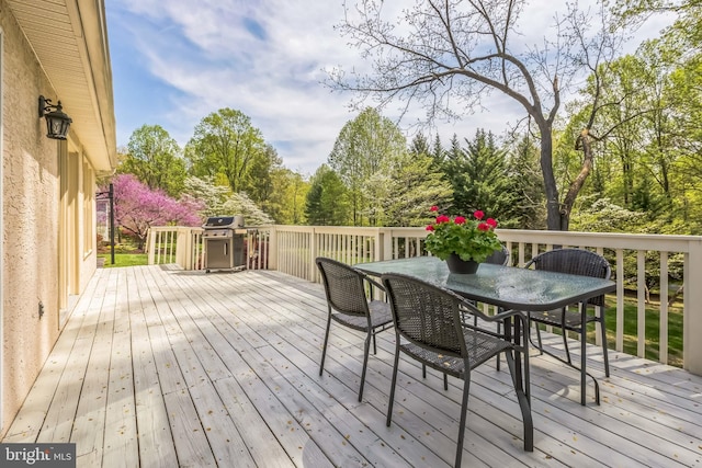 deck with a grill and outdoor dining area