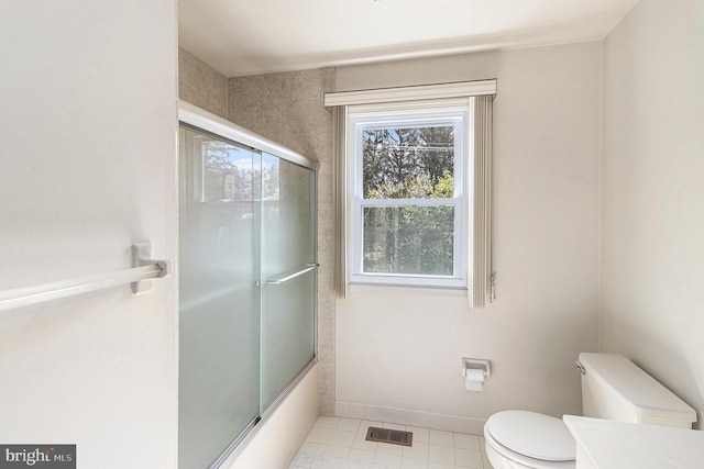 bathroom with visible vents, tile patterned floors, vanity, toilet, and shower / bath combination with glass door
