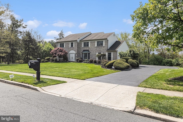 colonial house with stone siding and a front lawn