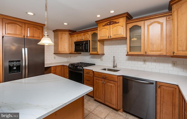 kitchen featuring a sink, appliances with stainless steel finishes, decorative backsplash, and glass insert cabinets