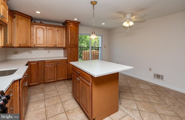 kitchen featuring a ceiling fan, visible vents, tasteful backsplash, brown cabinets, and light tile patterned flooring
