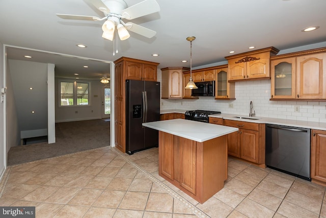 kitchen featuring glass insert cabinets, ceiling fan, light countertops, a sink, and black appliances
