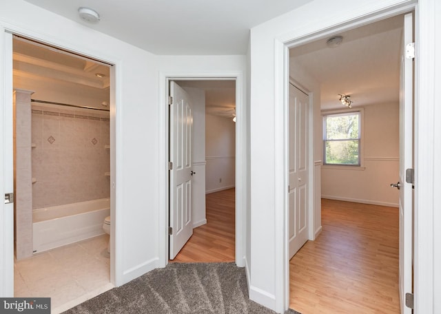 hallway with baseboards and wood finished floors