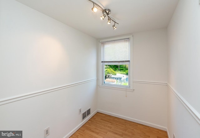 spare room with visible vents, light wood-style flooring, and baseboards