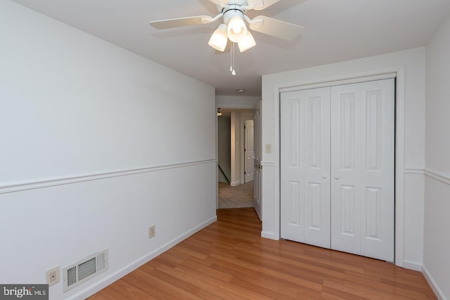 unfurnished bedroom with visible vents, a closet, baseboards, a ceiling fan, and light wood finished floors