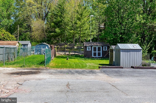 view of yard featuring fence, an outdoor structure, and a shed
