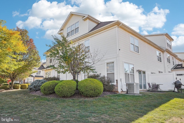 view of side of home with a patio, central air condition unit, and a yard