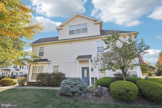 american foursquare style home featuring roof with shingles