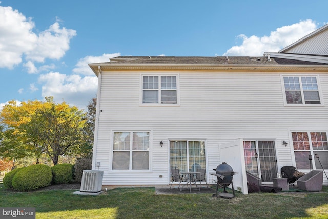 rear view of property featuring a lawn, cooling unit, and a patio