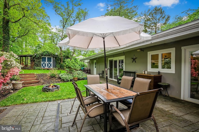 219 Gateswood Rd, Lutherville Timonium, MD 21093 - view of patio / terrace with an outdoor structure, outdoor dining space, a fire pit, and a storage shed