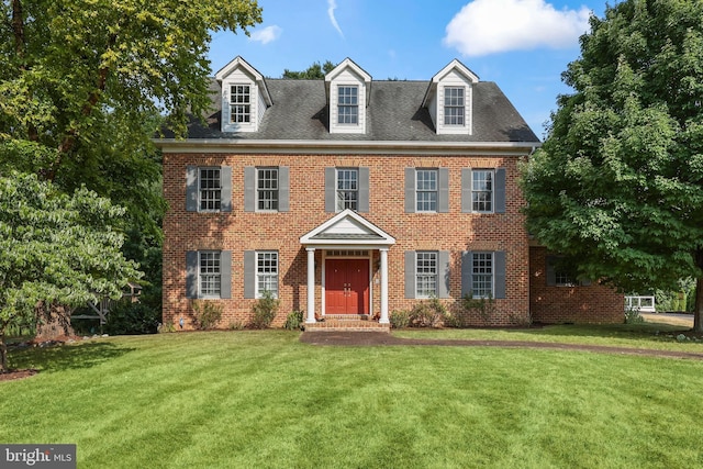 colonial home with a front yard and brick siding