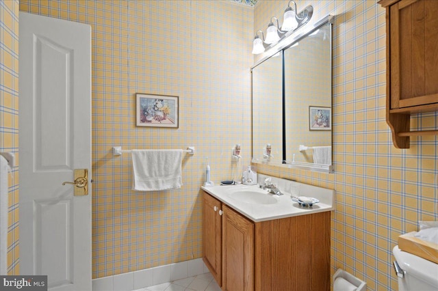half bathroom featuring toilet, tile walls, tile patterned flooring, and vanity
