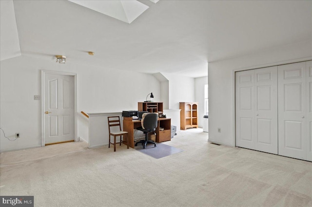 carpeted home office with a skylight and baseboards