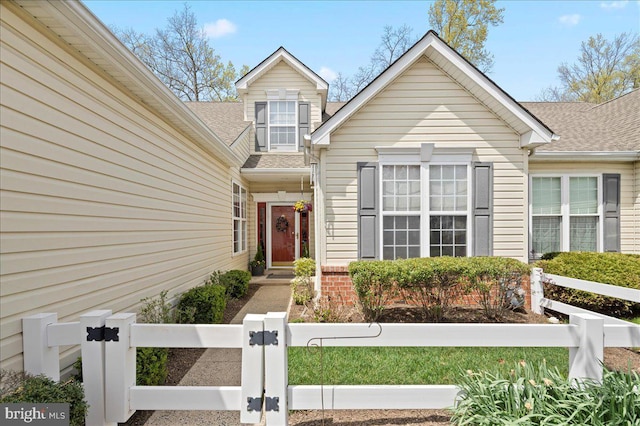 view of front of house with fence private yard and roof with shingles
