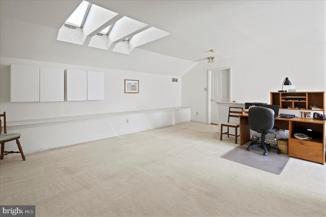 carpeted office featuring lofted ceiling with skylight