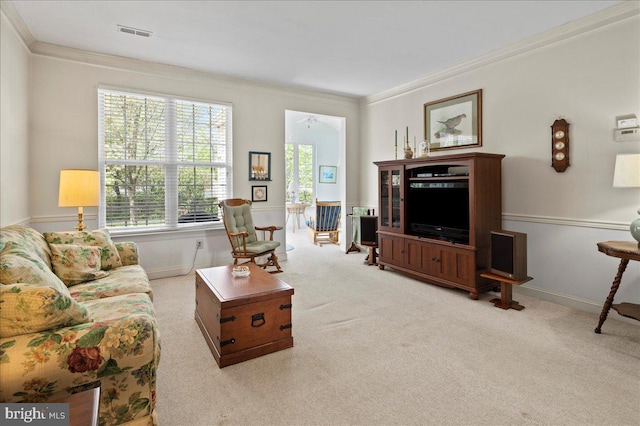carpeted living room featuring baseboards, ornamental molding, and visible vents