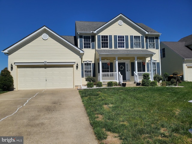 colonial home featuring a porch, a garage, a front lawn, and concrete driveway
