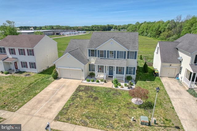 220 Nugent Loop, Smyrna, DE 19977 - colonial-style house with covered porch, an attached garage, concrete driveway, and a front lawn