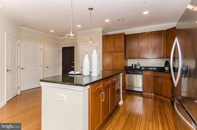kitchen with brown cabinets, stainless steel appliances, crown molding, and wood finished floors